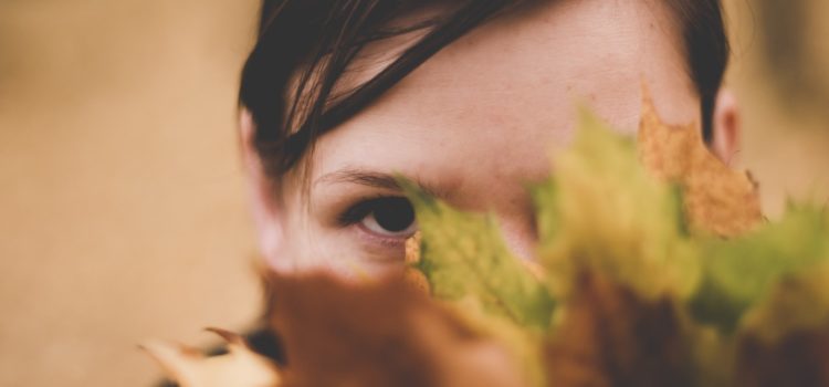 Kvinna med social ångest gömmer sig bakom löv