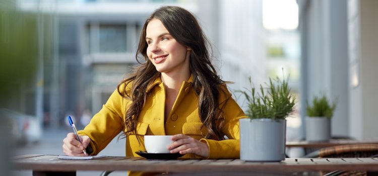Leende kvinna sitter på ett kafe